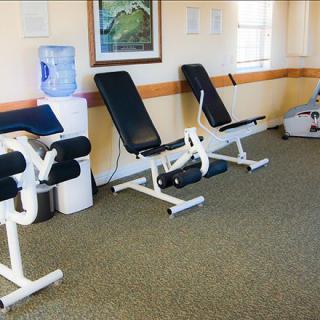 A small fitness room equipped with leg machines and a water dispenser.