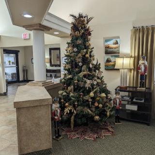A beautifully decorated Christmas tree in a cozy lobby setting, inviting the holiday spirit.