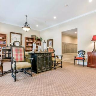 A traditional office setting with a desk, chairs, and bookshelves.