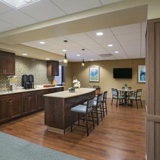 A modern kitchen and dining area with wood flooring and counter seating.