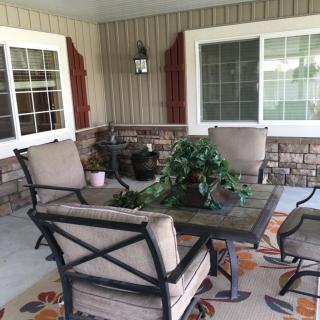 A cozy patio setup with comfortable chairs surrounding a table, adorned with a potted plant.