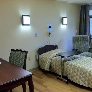 A hospital room with a bed and furniture, providing a comfortable environment for patients.