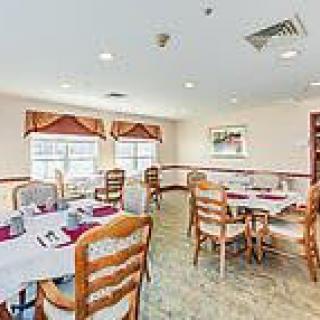 A bright and neatly arranged dining room with tables set for service.