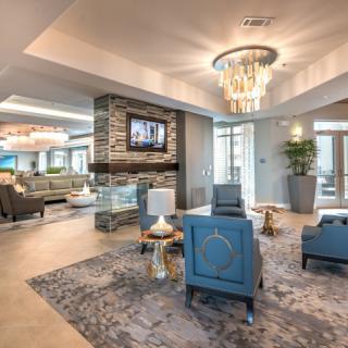 A luxurious and modern living room with elegant furnishings, featuring a chandelier, fireplace, and comfortable seating.