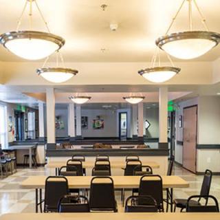 An empty conference room with arranged tables and chairs under elegant lighting.