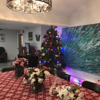 A warmly decorated dining room with a Christmas tree and a festive table setting.