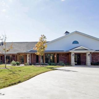 A suburban residential house with a spacious driveway and well-maintained lawn.