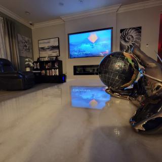 A modern living room featuring contemporary artwork and a large television.