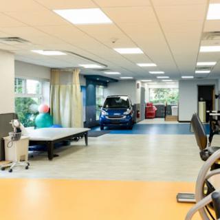 A bright and spacious rehabilitation center featuring various exercise equipment and therapy areas.