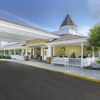 A picturesque building entrance with a covered porch and driveway.