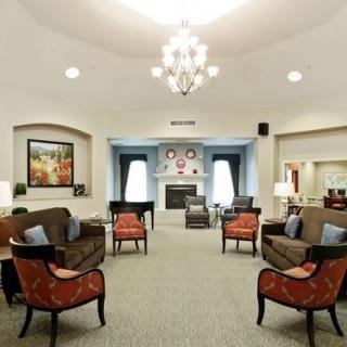 A well-furnished living room with a chandelier, seating area, and fireplace.