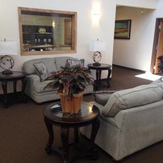 A cozy living room with sofas, a coffee table, and indoor plants.