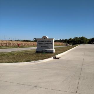 Entrance sign leading to a spacious recreational area under a clear blue sky.
