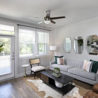 A modern, minimalist living room with a gray sofa and stylish decor.
