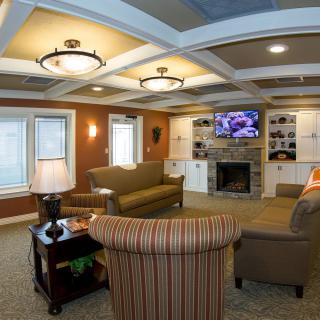 A cozy living room with comfortable seating, a fireplace, and a mounted television.
