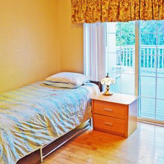 A cozy bedroom with a single bed and large window.
