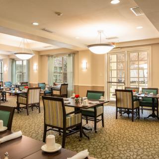 A well-lit dining room with neatly arranged tables and chairs, showcasing a cozy and inviting atmosphere.