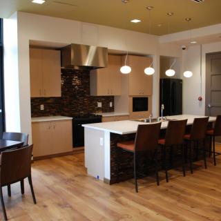 A modern kitchen with a large island and stylish lighting fixtures.