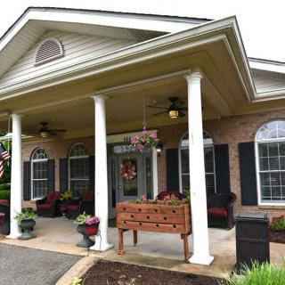 A welcoming building entrance with columns and outdoor seating.