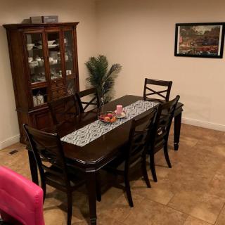 A cozy dining room with a wooden table, chairs, and a cabinet.