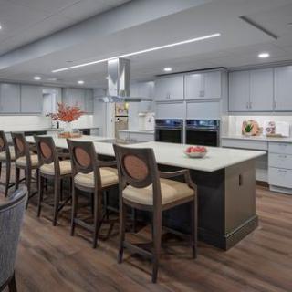 A modern kitchen interior featuring a large island with bar stools and sleek appliances.