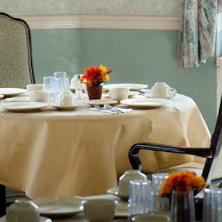 An elegant dining table set with fine china and a colorful floral arrangement, ready for guests.