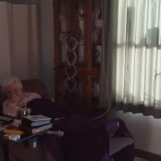An elderly patient resting in a hospital room with natural light streaming in through the window.