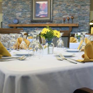 A beautifully set dining table adorned with floral centerpieces and fine glassware.