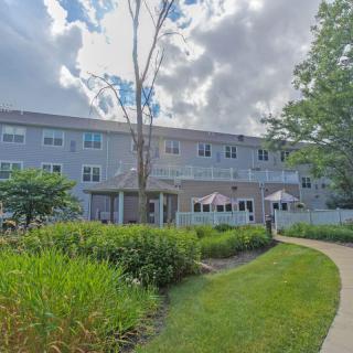 A view of a building surrounded by a well-maintained garden under a cloudy sky.