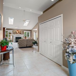 A modern living room with a cozy fireplace, elegant furnishings, and decorative plants.