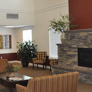A cozy living room with a stone fireplace and comfortable seating.