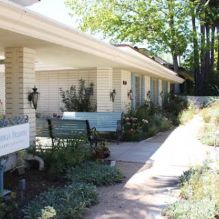 A charming residential setting with well-maintained gardens and a welcoming pathway.