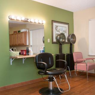 A cozy hair salon interior with styling chairs, a mirror, and salon equipment.