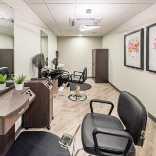 A modern hair salon interior with styling chairs and mirrors.