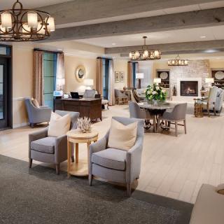 A cozy and elegantly designed living room with comfortable seating, warm lighting, and a fireplace, creating an inviting atmosphere.