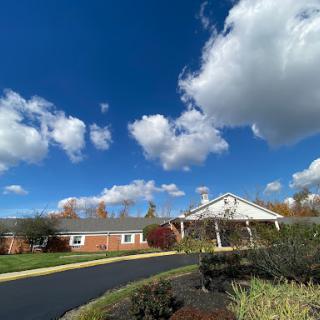 A picturesque building under a bright blue sky adorned with fluffy clouds.