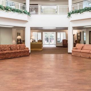 A spacious lobby area with comfortable sofas and a wooden floor.