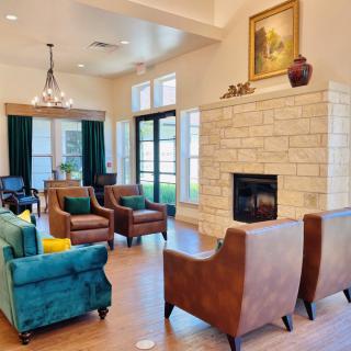 A cozy living room featuring a stone fireplace, comfortable seating, and elegant decor.