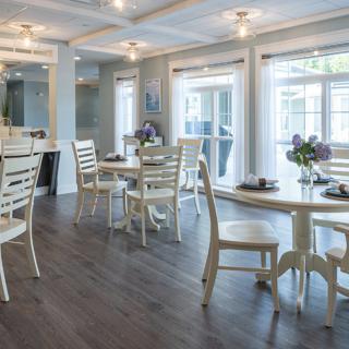 A cozy and modern restaurant interior with natural lighting and neatly arranged tables and chairs.