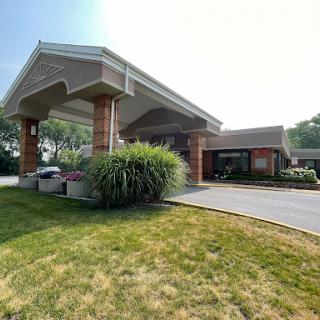 A welcoming entrance to a well-designed building with a manicured lawn.