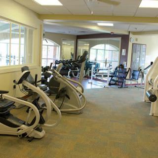 A spacious gym area featuring various exercise machines and equipment, ideal for workouts.
