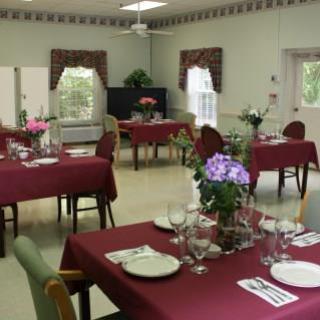 A cozy dining area set up for a meal, featuring elegantly decorated tables with flowers.