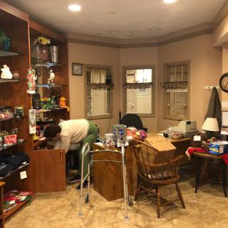 A cozy but cluttered room filled with various items and furniture.