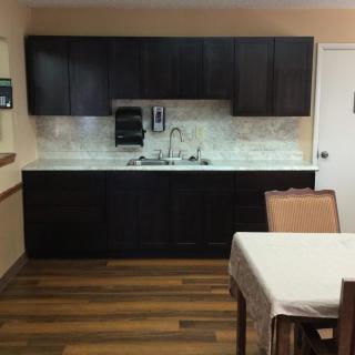A kitchen area with dark cabinets, a countertop, and a sink.
