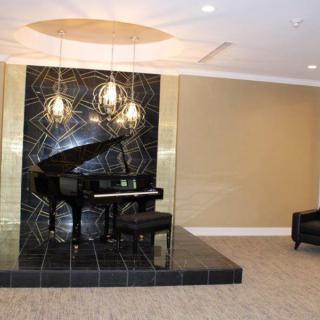 A stylish lounge featuring a grand piano with modern lighting.