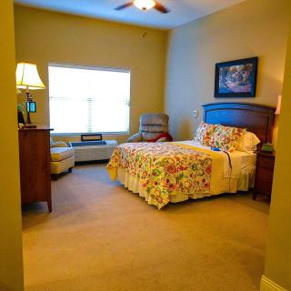 A cozy bedroom with colorful bedding and warm lighting.