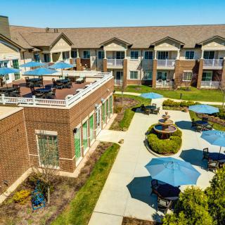 Aerial view of a residential building with a courtyard featuring outdoor seating and umbrellas.