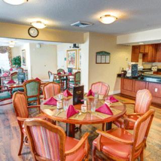 A cozy dining area with a set table and chairs, adjacent to a kitchen space.