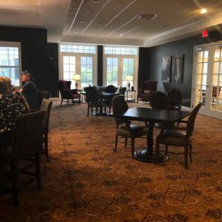 Cozy dining area with tables and chairs, featuring large windows for natural light.