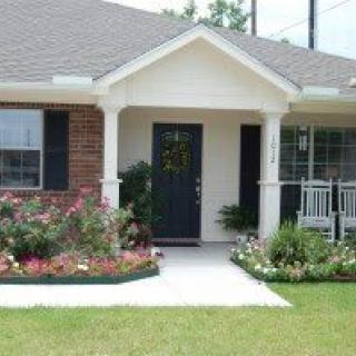 A charming house with a front porch and well-maintained garden.